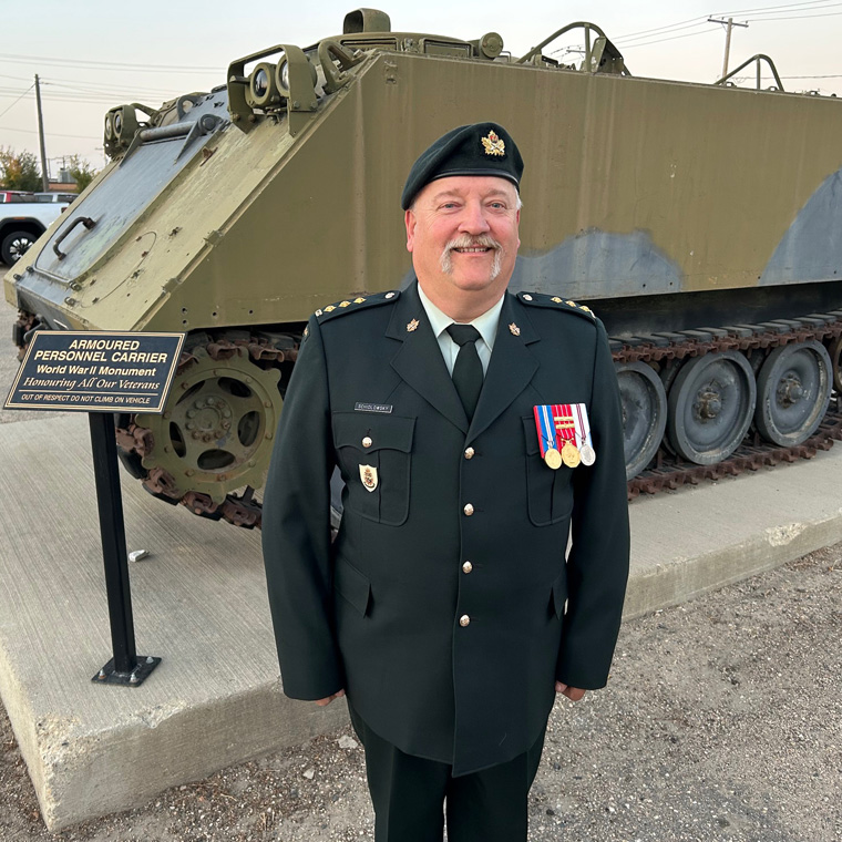 Image of a tank that is a part of the museum plus a cadet in full uniform