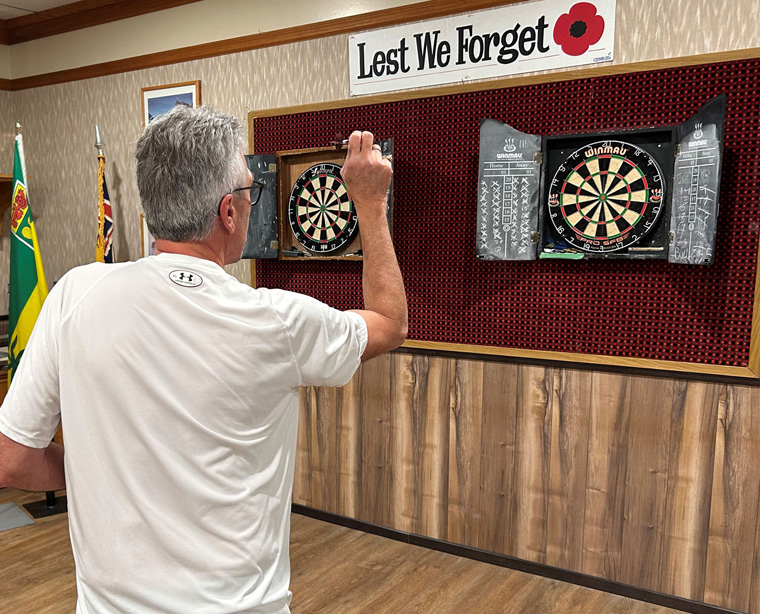 Image of a man playing darts at the Humboldt Legion Clubroom